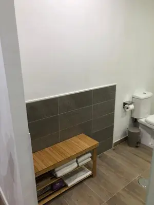 a bathroom with a toilet and a wooden table at La Estación in Sanlúcar de Barrameda