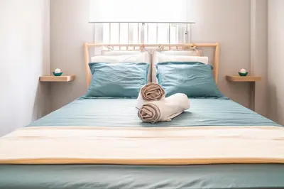 a bed with a head board with a towel on it at Apartamento AGUASAL in Sanlúcar de Barrameda