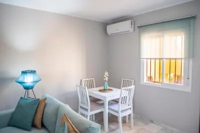a living room with a table and chairs and a couch at Apartamento AGUASAL in Sanlúcar de Barrameda