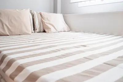 a bed with white sheets and pillows on it at Apartamento AGUASAL in Sanlúcar de Barrameda