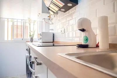 a kitchen with a sink and a hair dryer on a counter at Apartamento AGUASAL in Sanlúcar de Barrameda