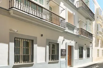 a white building with balconies on the side of it at Tandem Pópulo in Cádiz