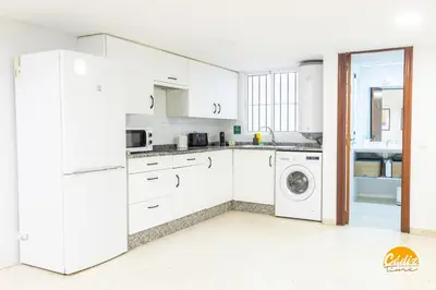 a kitchen with white cabinets and a washer and dryer at Gallery Home by LiveWork in Cádiz