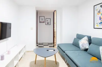 a living room with a blue couch and a table at Gallery Home by LiveWork in Cádiz
