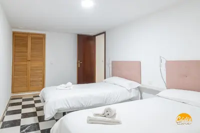 a hotel room with two beds and a checkered floor at Gallery Home by LiveWork in Cádiz