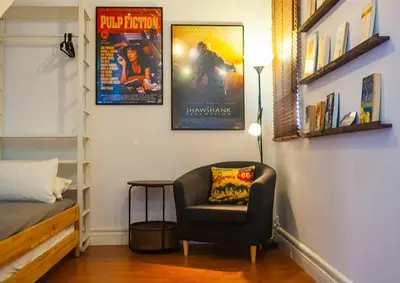 a bedroom with a chair and posters on the wall at SH La Casa del Capitán. Cerca de la catedral. in Cádiz
