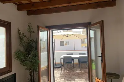 a dining room with a table and an umbrella at Hidden Gem Penthouse Populo y Catedral in Cádiz