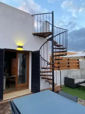 a spiral staircase on the side of a house at Hidden Gem Penthouse Populo y Catedral in Cádiz