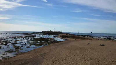 a sandy beach with a pier and the ocean at Caleta Dreams. Apartamento a estrenar. A 60 metros Playa in Cádiz