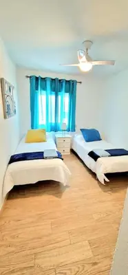 a bedroom with two beds and a ceiling fan at Precioso apartamento en el corazón histórico in El Puerto de Santa María