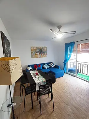a living room with a blue couch and a table at Precioso apartamento en el corazón histórico in El Puerto de Santa María