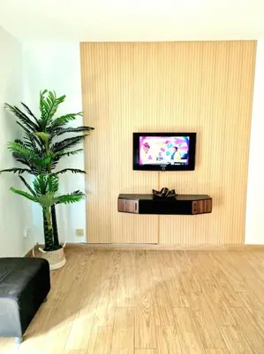 a living room with a tv and a palm tree at Precioso apartamento en el corazón histórico in El Puerto de Santa María