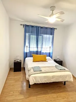 a bedroom with a bed with a yellow pillow and a window at Precioso apartamento en el corazón histórico in El Puerto de Santa María