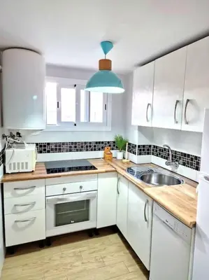 a kitchen with white cabinets and a sink at Precioso apartamento en el corazón histórico in El Puerto de Santa María