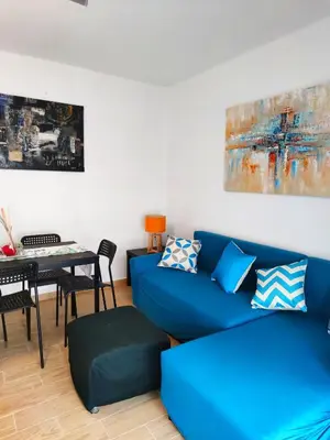 a living room with a blue couch and a table at Precioso apartamento en el corazón histórico in El Puerto de Santa María