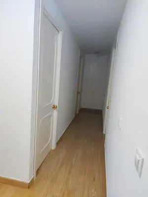 an empty hallway with white walls and wood floors at Precioso apartamento en el corazón histórico in El Puerto de Santa María