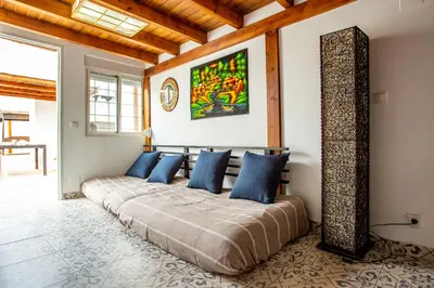 a large bed in a room with blue pillows at Villa Tokio con jacuzzi y piscina privada in Chiclana de la Frontera