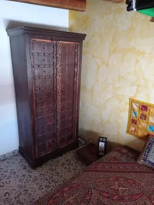 a bedroom with a wooden cabinet next to a bed at Villa Tokio con jacuzzi y piscina privada in Chiclana de la Frontera