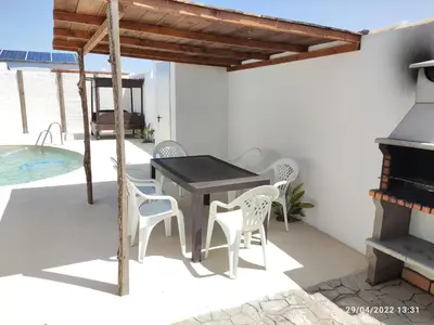 a patio with a table and chairs and a pool at Villa Tokio con jacuzzi y piscina privada in Chiclana de la Frontera