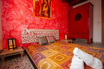 a bedroom with a bed and a red wall at Villa Tokio con jacuzzi y piscina privada in Chiclana de la Frontera