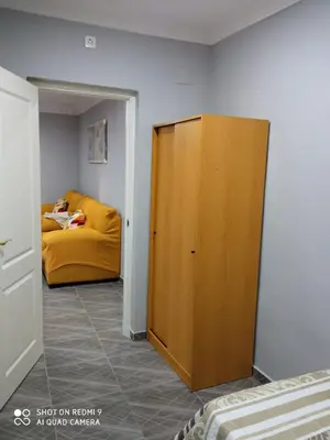 a wooden cabinet in a room with a yellow couch at Casa La Maravilla in Jerez de la Frontera