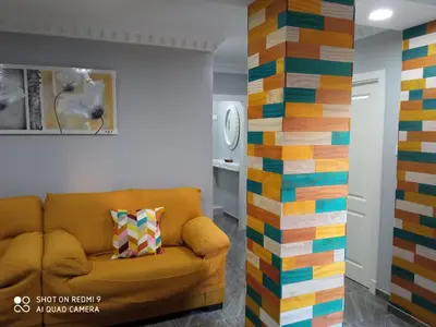 a living room with a couch and a colorful wall at Casa La Maravilla in Jerez de la Frontera