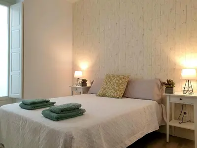a bedroom with a bed with green towels on it at Sherryflat Cádiz in Cádiz