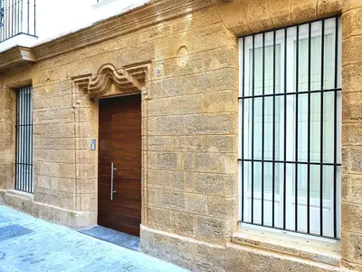 a brown brick building with a wooden door at Sherryflat Cádiz in Cádiz