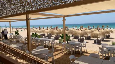 a group of tables and chairs on the beach at Sherryflat Cádiz in Cádiz