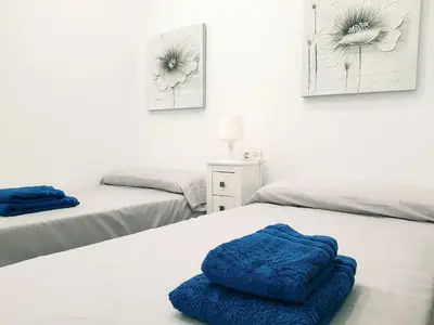 a room with two beds with blue towels on them at Sherryflat Cádiz in Cádiz