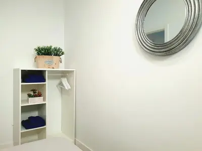 a mirror on a wall next to a shelf with a plant at Sherryflat Cádiz in Cádiz