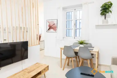 a living room with a table and a tv at Estudio Palma by LiveWork in Cádiz