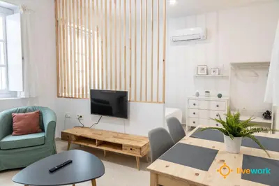 a living room with a table and a tv at Estudio Palma by LiveWork in Cádiz