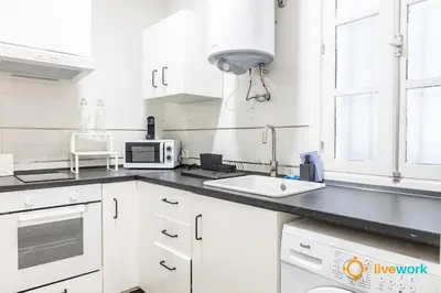 a white kitchen with a sink and a microwave at Estudio Palma by LiveWork in Cádiz