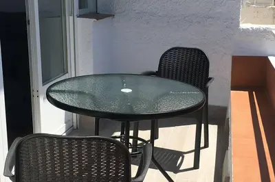 a glass table and two chairs in a room at Apartamento a estrenar en un lugar emblemático in Conil de la Frontera
