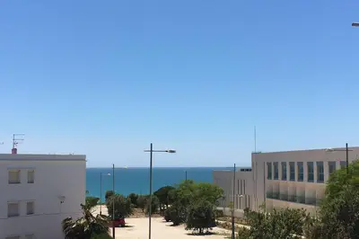 a city street with buildings and the ocean in the background at Apartamento a estrenar en un lugar emblemático in Conil de la Frontera