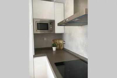 a kitchen with white cabinets and a microwave at Apartamento a estrenar en un lugar emblemático in Conil de la Frontera