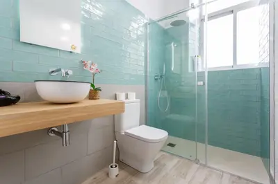 a bathroom with a toilet and a glass shower at TACITA Family Home by Cadiz4Rentals in Cádiz