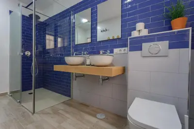 a blue tiled bathroom with two sinks and a shower at TACITA Family Home by Cadiz4Rentals in Cádiz
