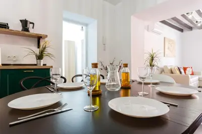 a dining room table with plates and wine glasses at TACITA Family Home by Cadiz4Rentals in Cádiz