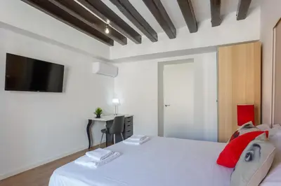 a bedroom with a white bed with a tv on the wall at TACITA Family Home by Cadiz4Rentals in Cádiz