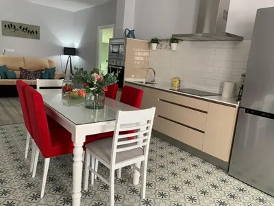 a kitchen with a table and red chairs in a room at LOFT CON ENCANTO in Arcos de la Frontera