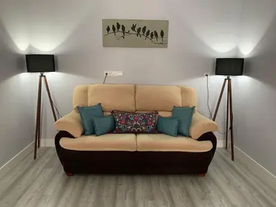 a couch in a living room with two lamps at LOFT CON ENCANTO in Arcos de la Frontera