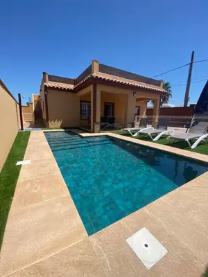 a swimming pool in front of a house at Villa Raquel in Conil de la Frontera
