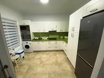 a kitchen with white cabinets and a black refrigerator at Villa Raquel in Conil de la Frontera