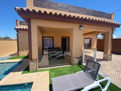 a villa with a swimming pool and a patio at Villa Raquel in Conil de la Frontera