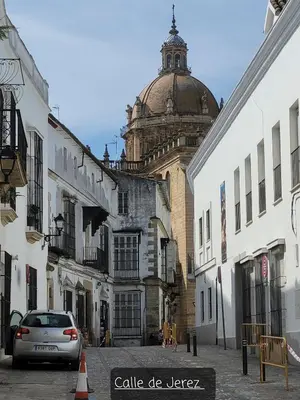 a car driving down a street with a building at Jerez Centro Historico in Jerez de la Frontera