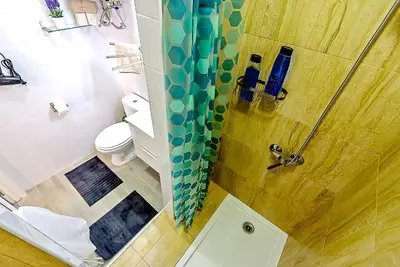 a bathroom with a shower with a toilet and a sink at Plaza Noria Apartments with Balconies in El Puerto de Santa María