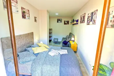 a bedroom with a bed with a blue blanket at Plaza Noria Apartments with Balconies in El Puerto de Santa María