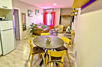 a kitchen and living room with a table and chairs at Plaza Noria Apartments with Balconies in El Puerto de Santa María